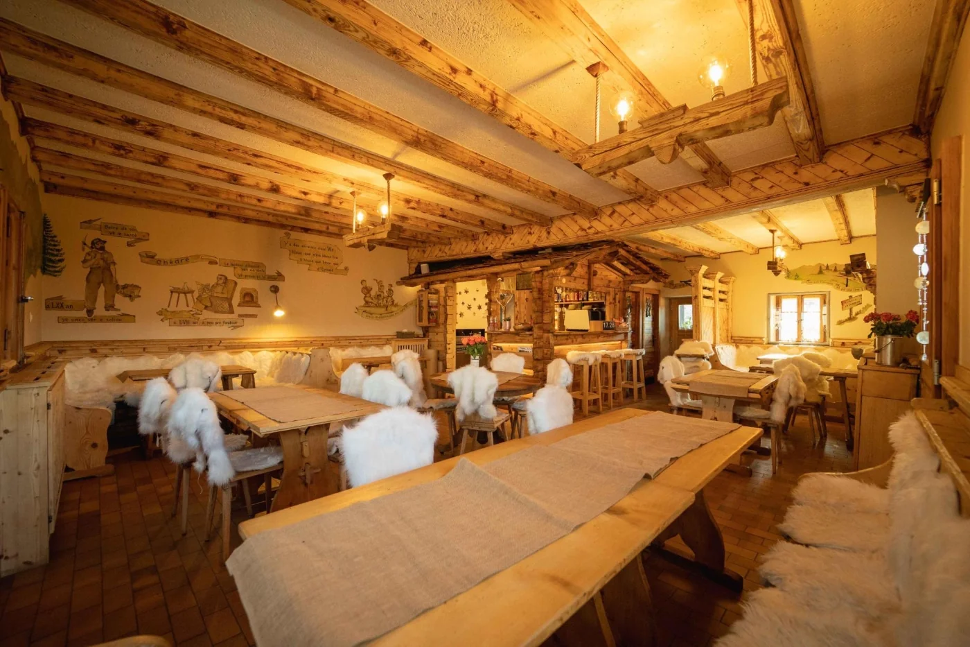 Salle intérieure chaleureuse avec tables en bois et peaux de mouton