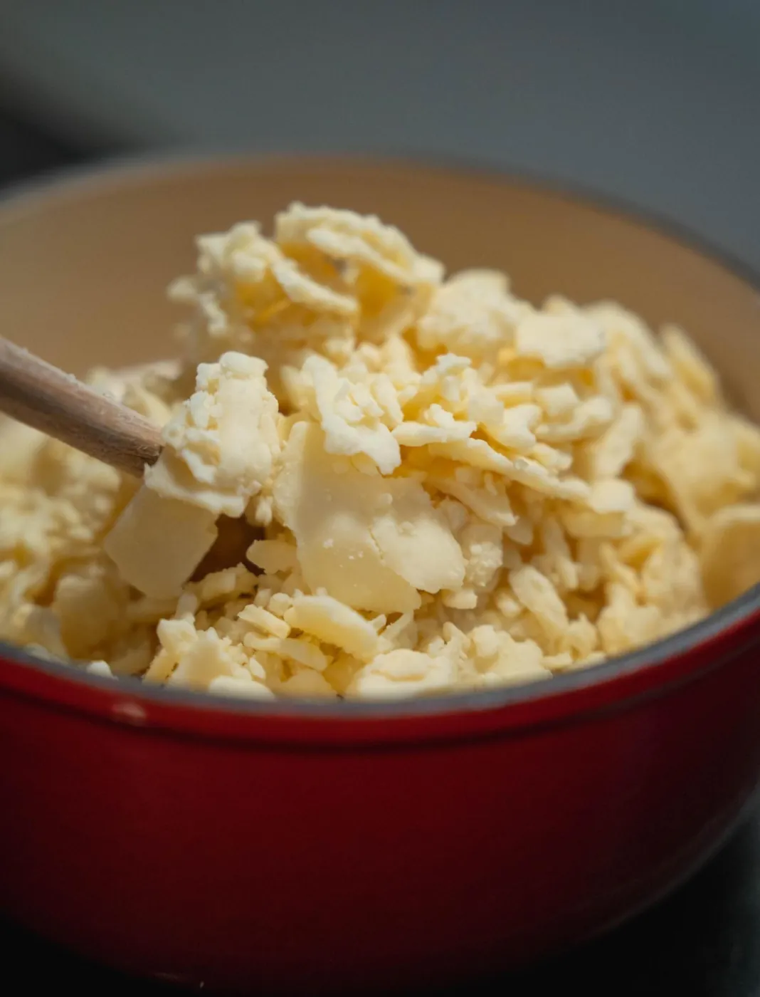 Préparation de la fondue : fromage râpé dans le caquelon