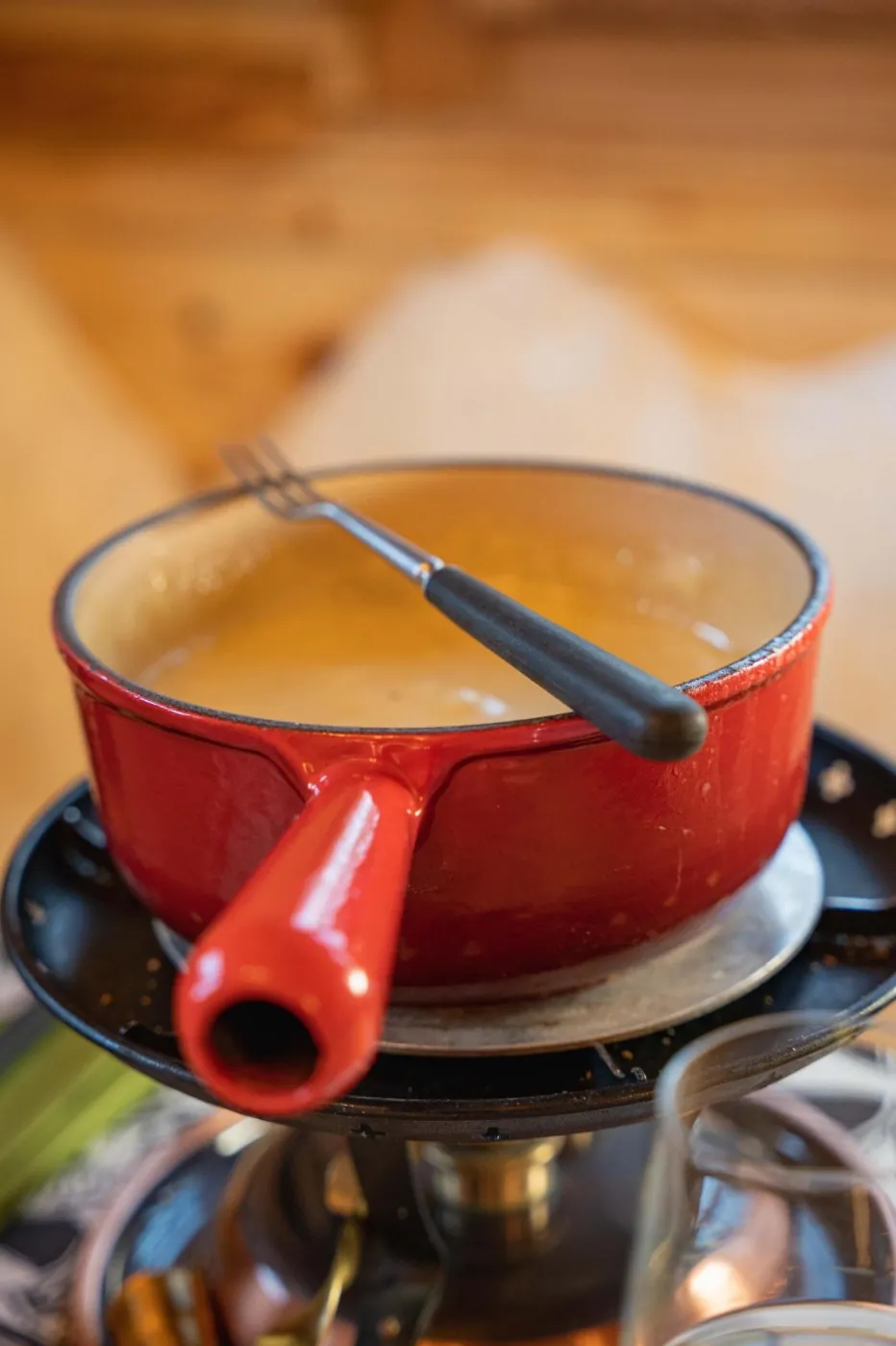 Gros plan sur un caquelon rouge et une fourchette à fondue